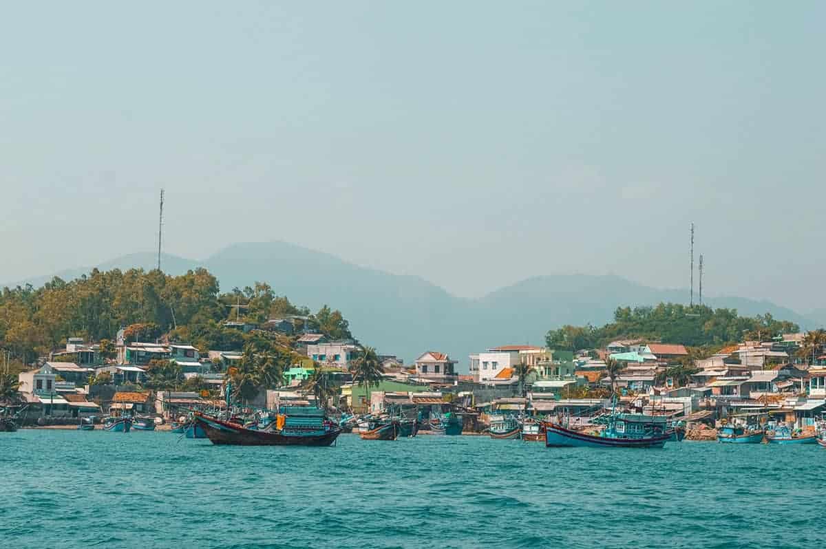 3 Day Nha Trang Itinerary & BEST Travel Tips 34 leaving nha trang on a boat looking back towards the mountains backpacking nha trang