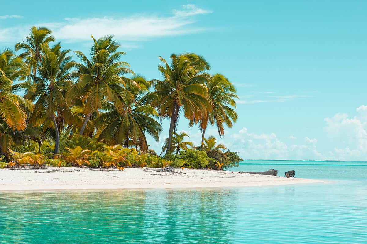 the bright blue waters of one foot island in aitutaki