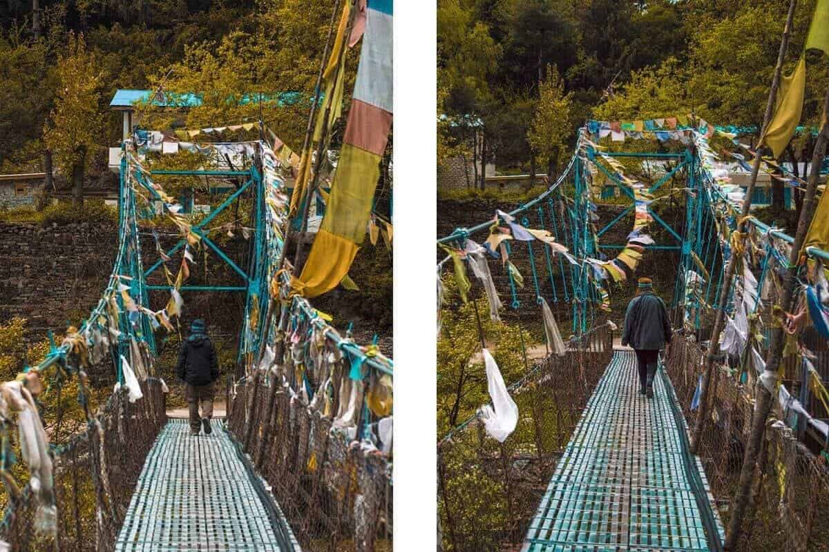 walking over a bridge in chame covered in pray flags