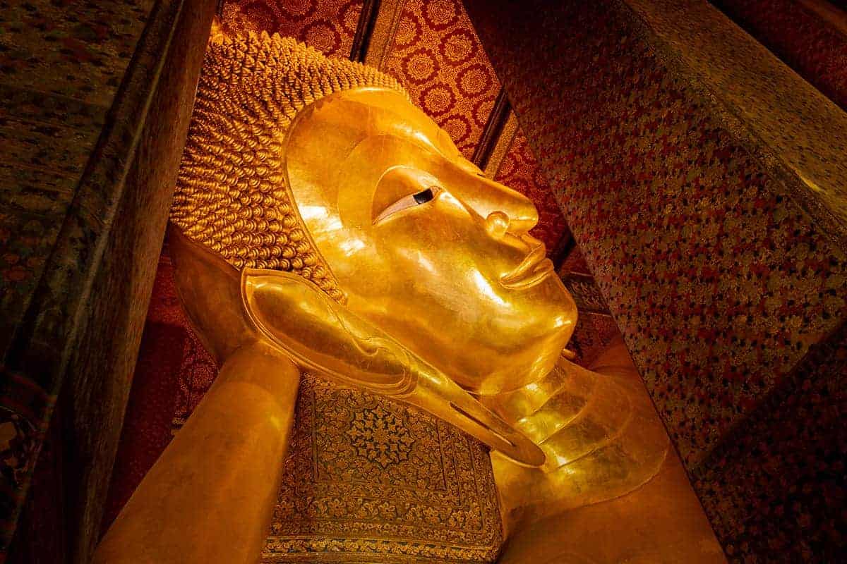 the face of the golden reclining buddha in wat po bangkok