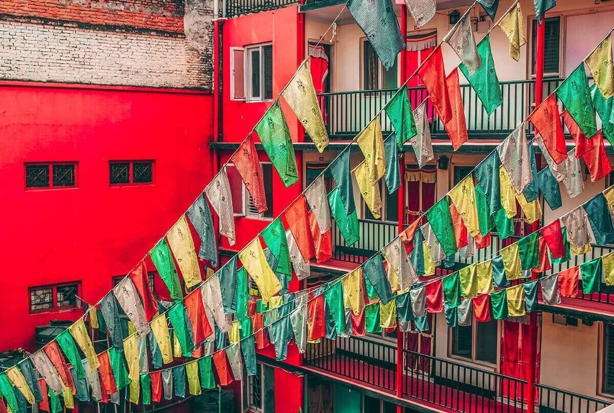 red buildings with pray flags hanging off the balcony in kathmandu