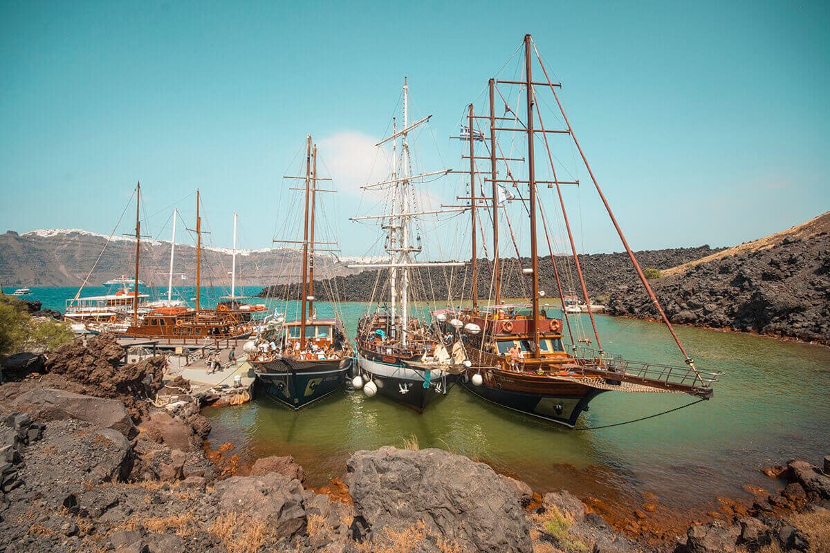 Backpacking Santorini On A Budget: All You Need To Know 16 sailboats at nea kameni backpacking santorini on a budget