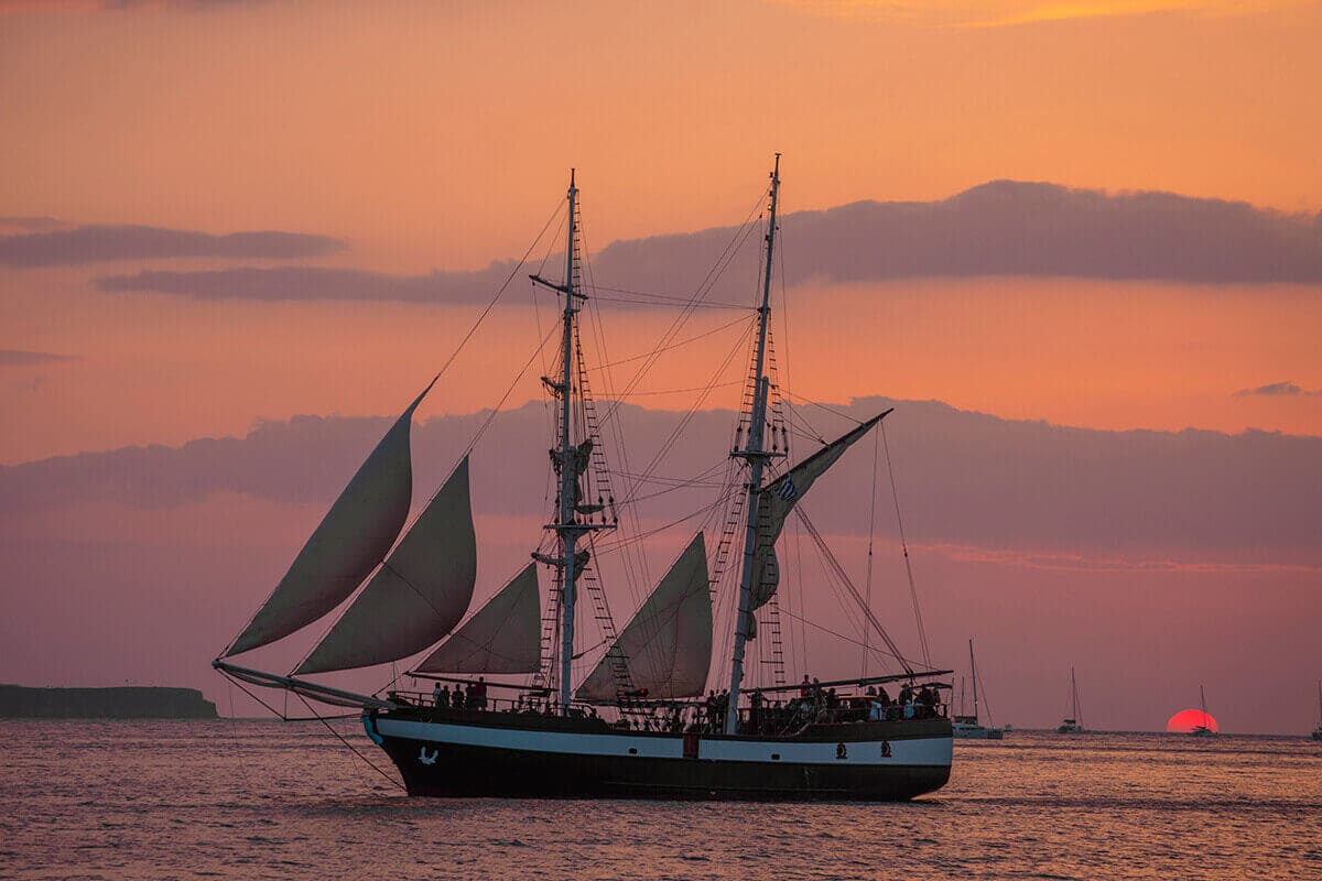 Backpacking Santorini On A Budget: All You Need To Know 14 sail boat at sunset backpacking santorini on a budget