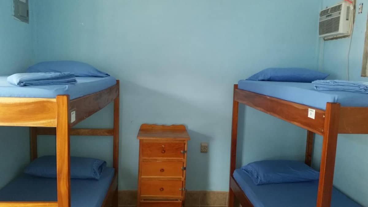 the dorm rooms at go slow hostel in caye caulker with the air conditioning unit up in the corner