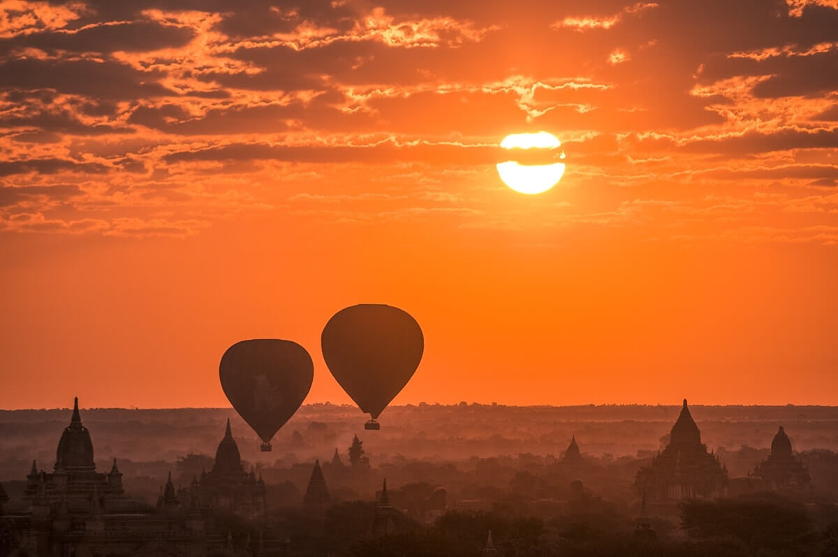 zoom shot of the temples in bagan with hot air balloons
