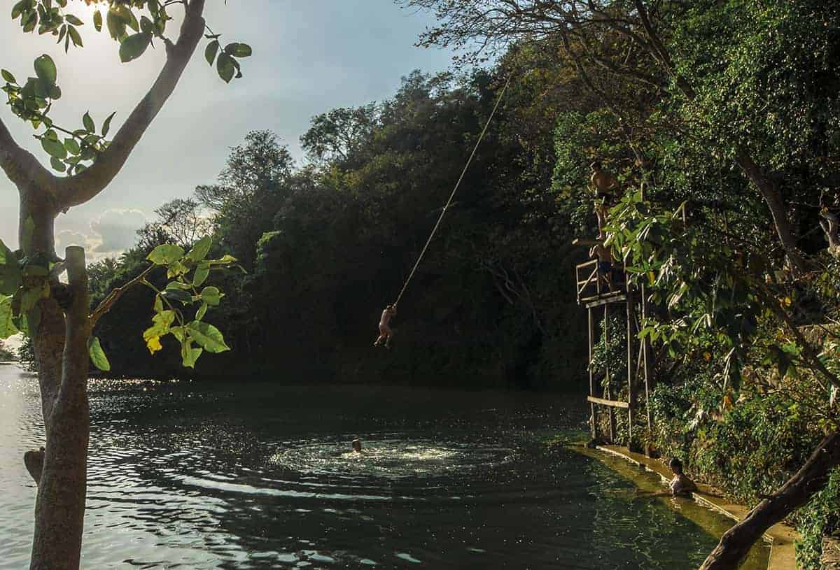 jumping into the water at jorges rope swing in flores guatemala