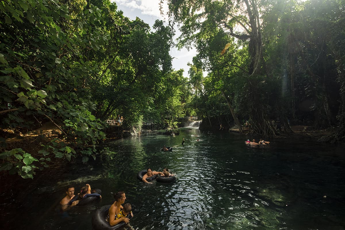 groups of people tubing alongside the river at the rarru cascades in port vila