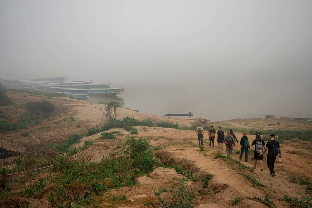 stray group walking to slow boat from homestay in laos