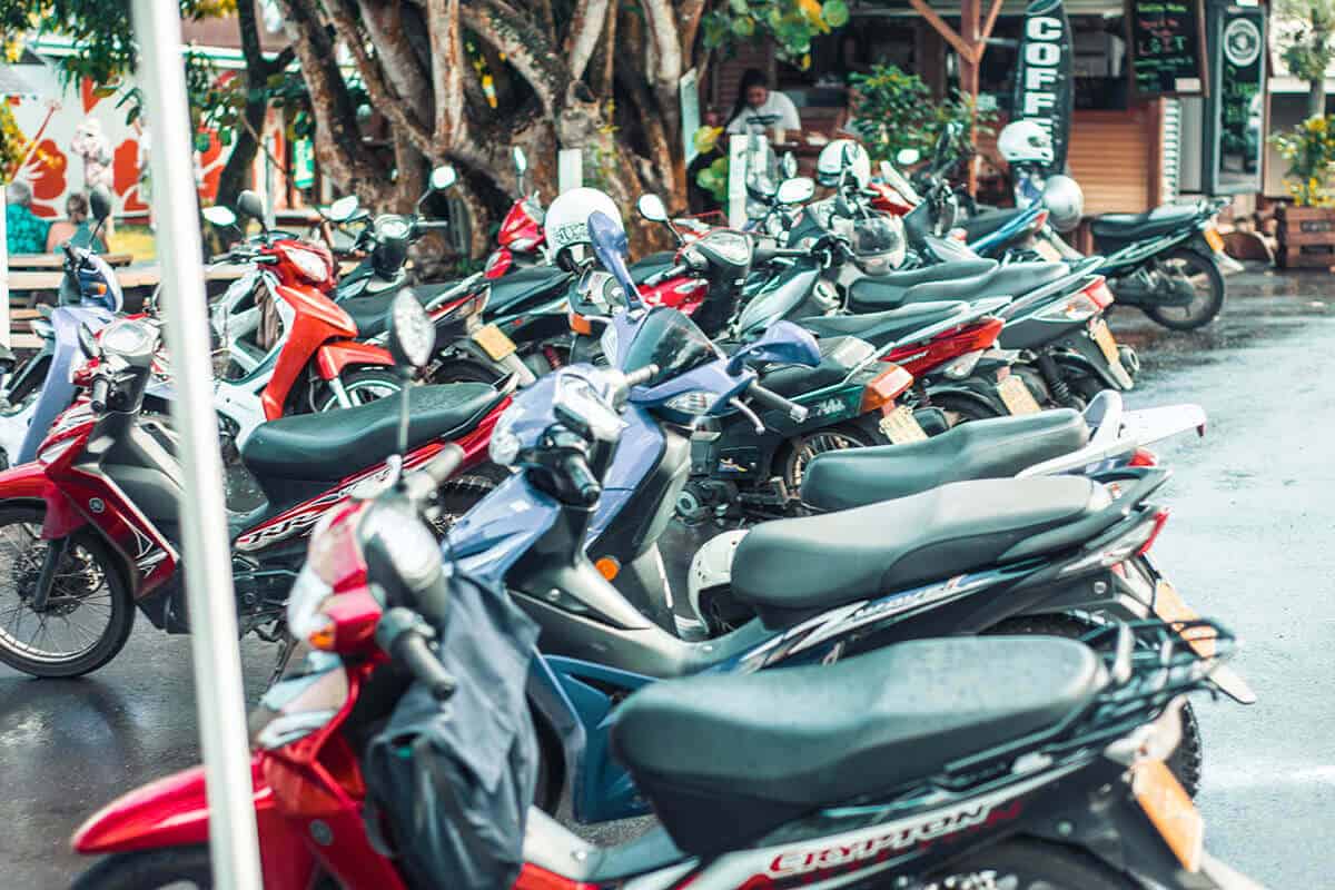 an assortment of scooters parked outside the market in rarotonga