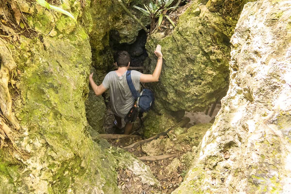 The Secret Grotto In Lifou: All You NEED To Know 2025 5 squeezing through the rocks to the entrance of the cave in lifou