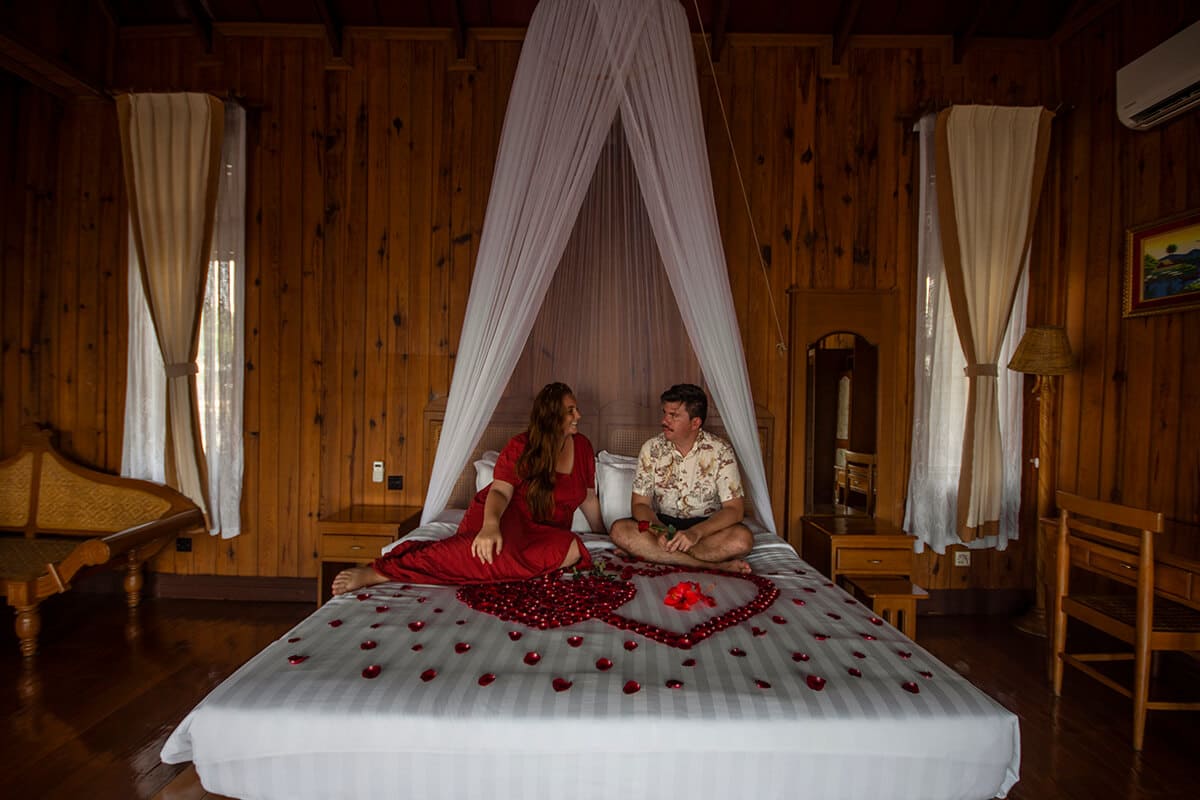 couple surrounded by rose petals on bed