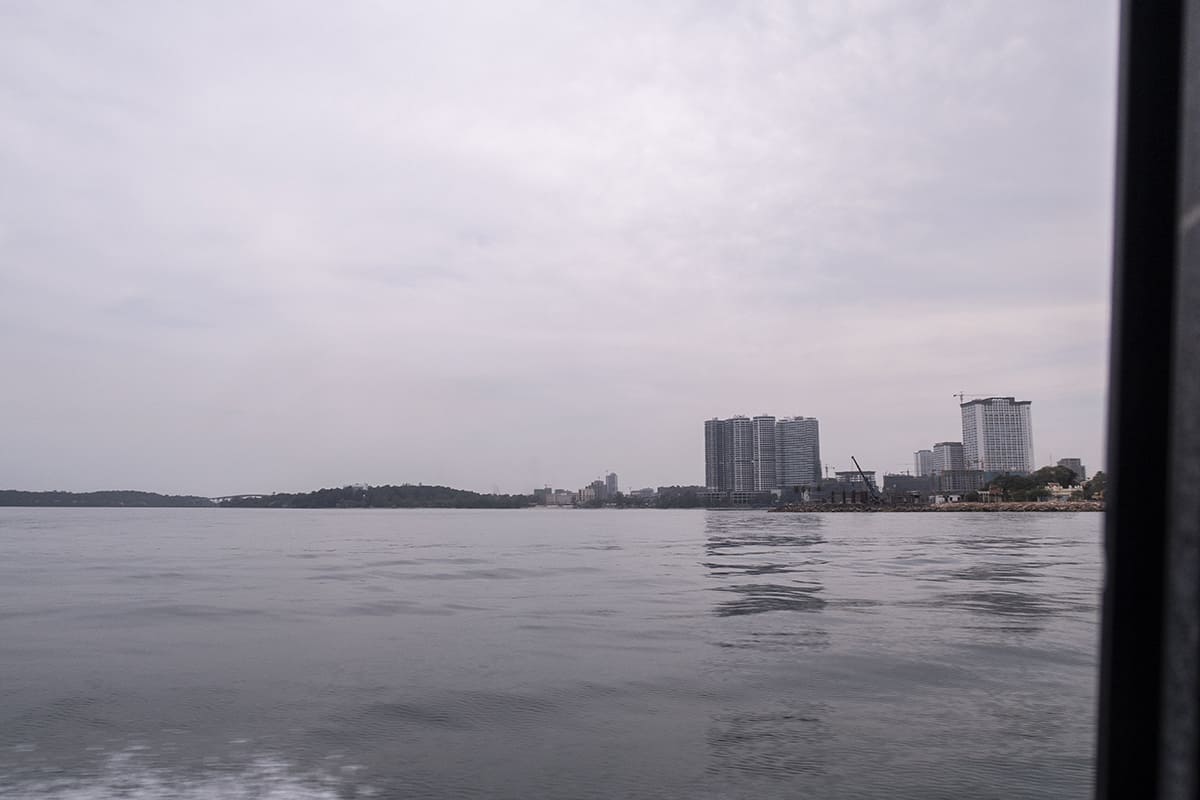 taking a speed boat from sihanoukville to koh rong with big sky scrappers on the mainland