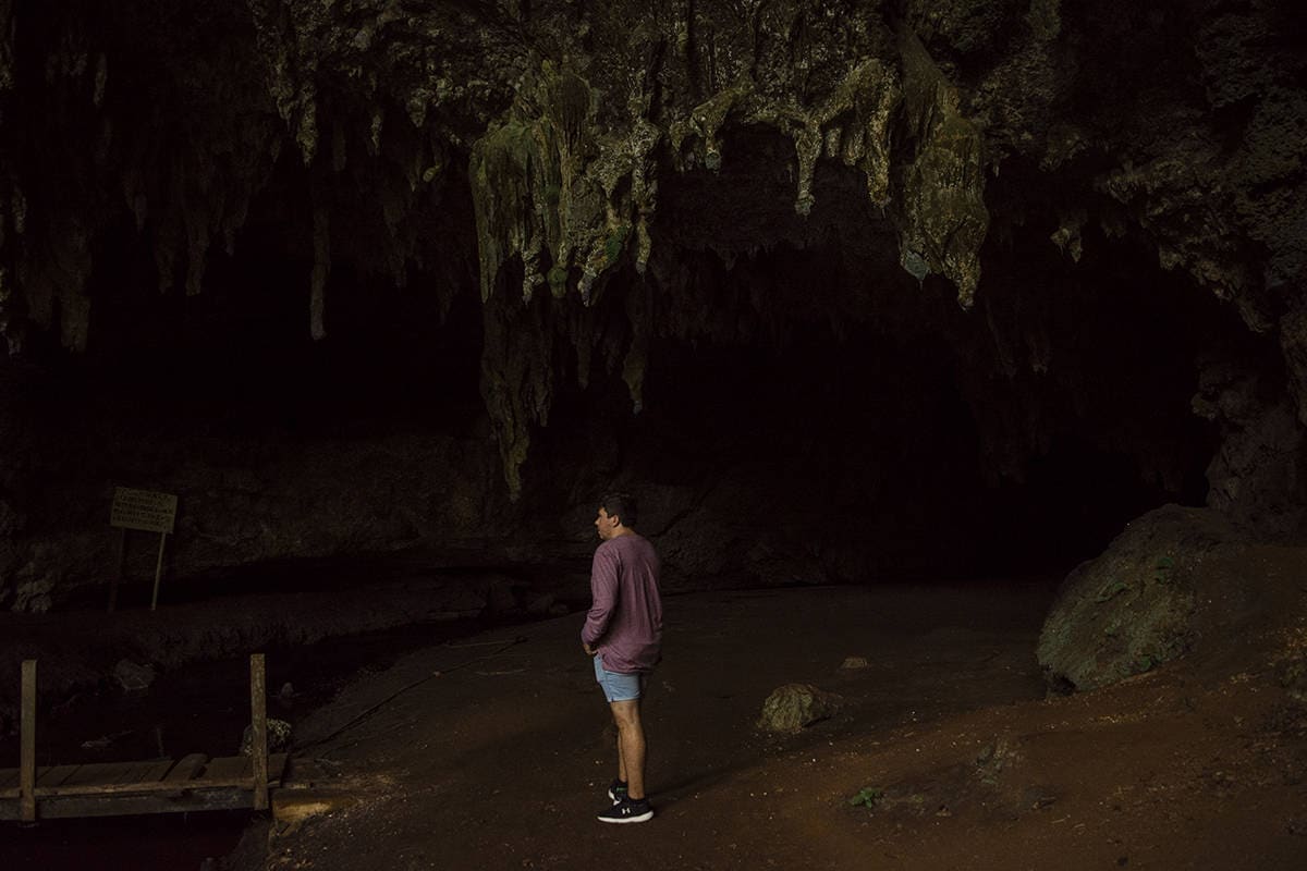 admiring the darkness and rock formations before venturing into queen hortense cave in isle of pines