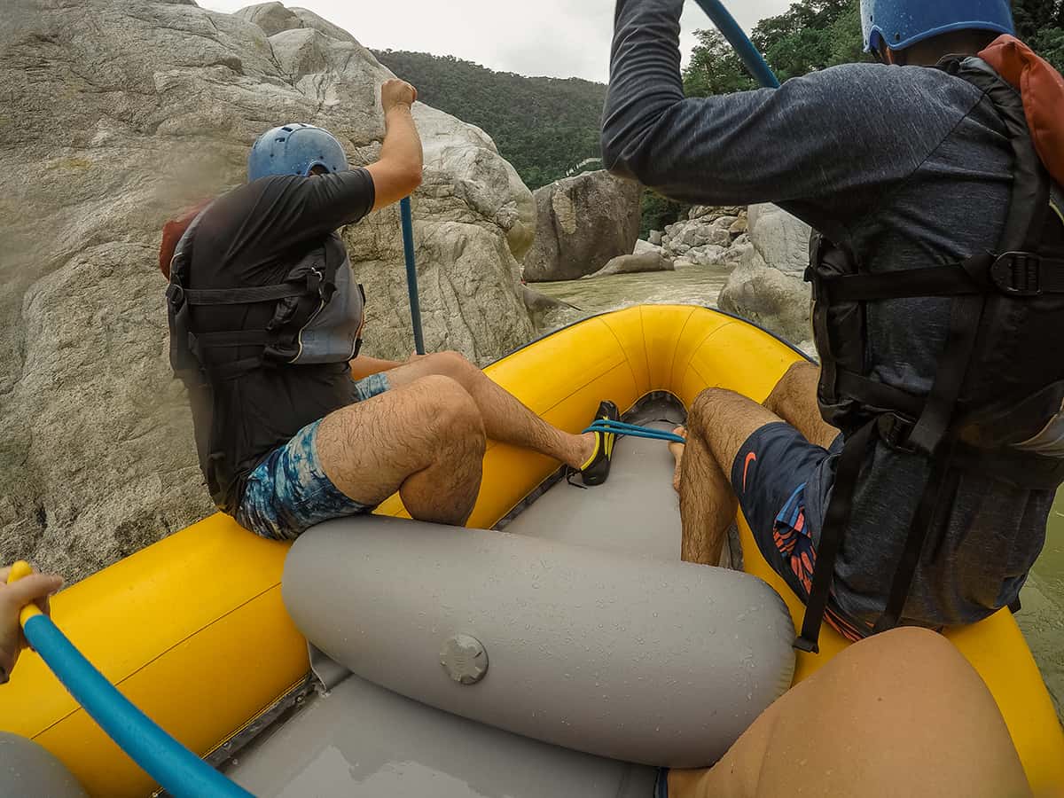 navigating past the boulders and through rapids while white water rafting in honduras