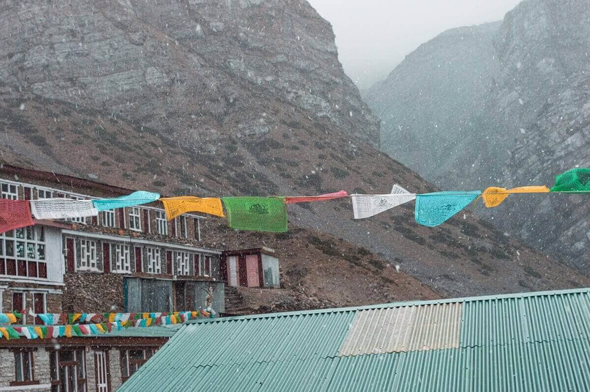 prayer flags in snow yak kharka to thorong phedi base camp on the annapurna circuit
