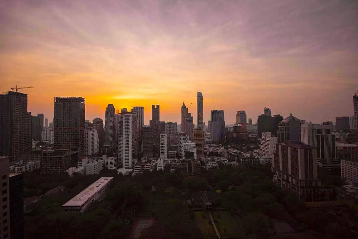 sunset over the bangkok skyline from a skybar