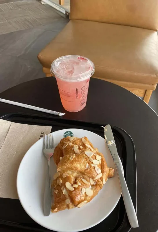 a almond crossiant and strawberry acai refresher from starbucks for breakfast in bangkok