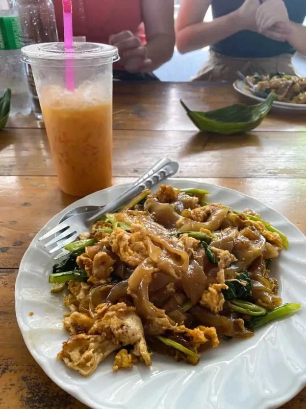 lunch consisting of pad see ew and a thai iced tea in bangkok