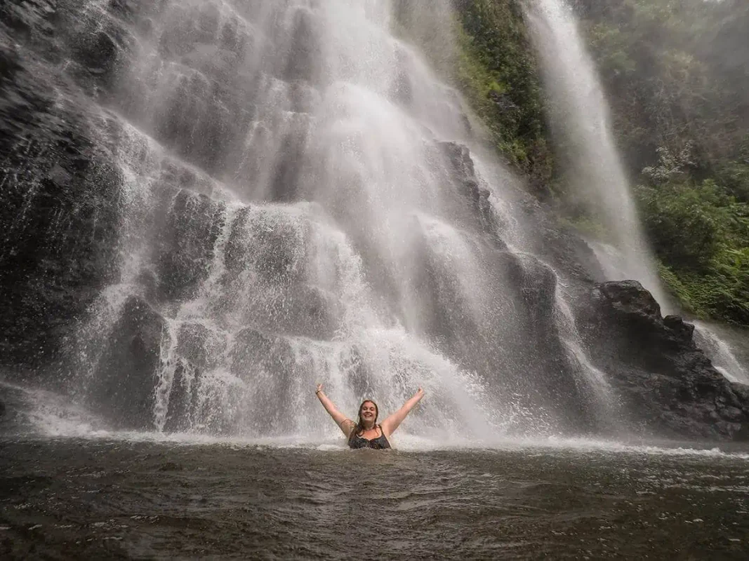tasha amy swimming underneath a waterfall outside of pakse