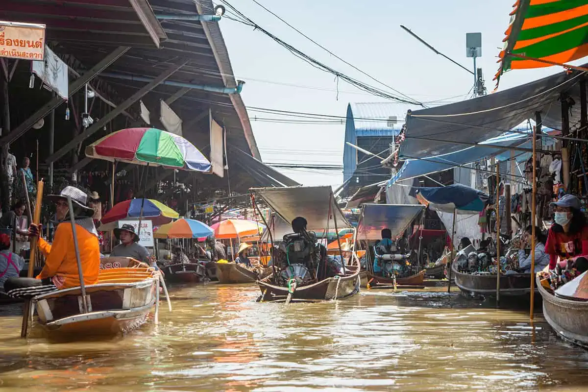 the midday rush at the bustling floating markets in bangkok, a must on the thailand backpacking route