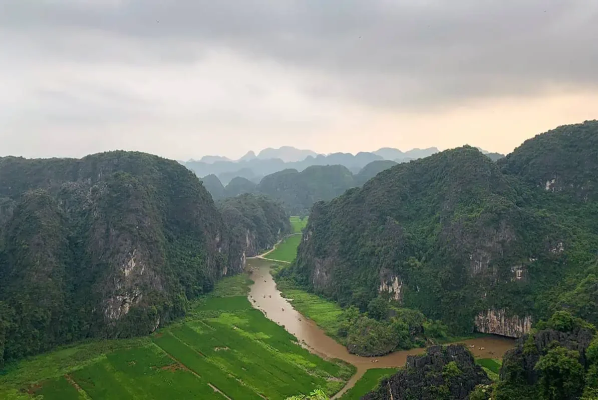Majestic view of a river winding through karst limestone mountains in Ninh Binh, a natural wonder for those spending 3 weeks in Vietnam.