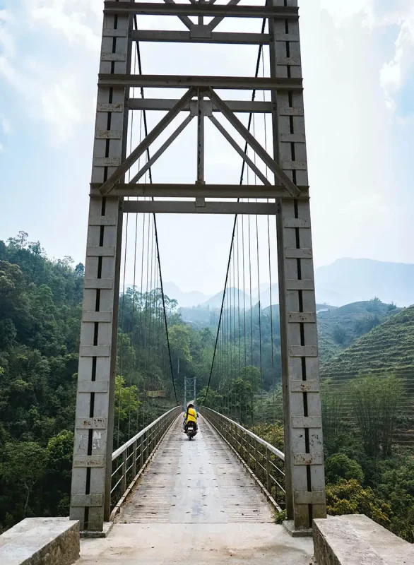 Solitary motorcyclist on a bridge in the mountainous regions of Vietnam, a journey to remember on a 3 week Vietnam adventure.