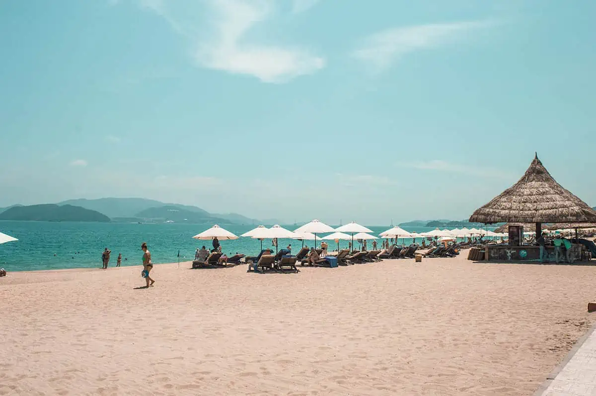 Serene beachfront with umbrellas and loungers under a clear sky, a slice of relaxation to be had during a 3 week Vietnam getaway.