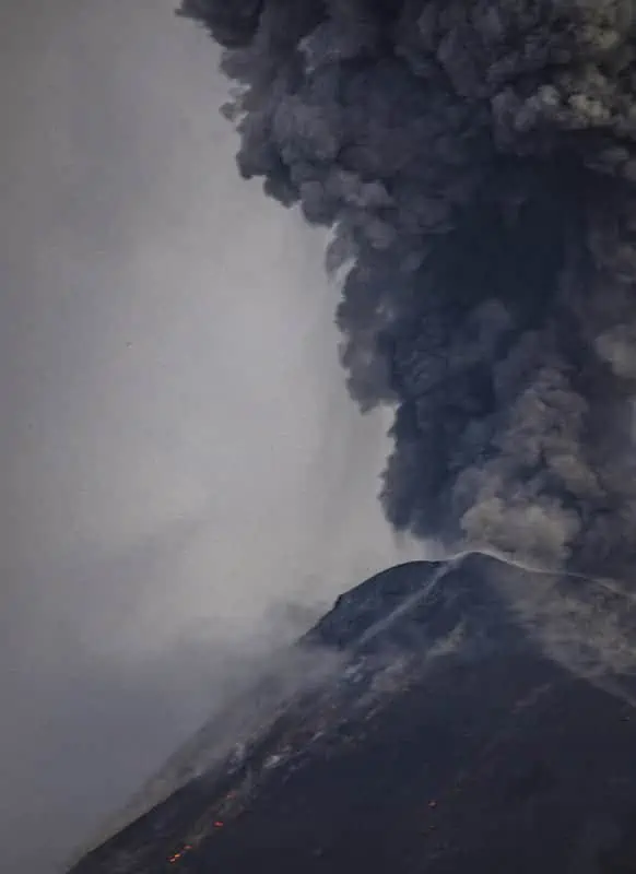 the sky turning dark with rocks and ash flying around during an eruption