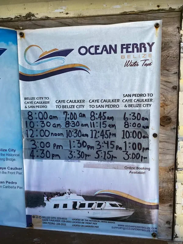 ocean ferry sign in caye caulker showing the ferry routes and times