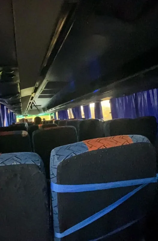 Interior of a bus with rows of seats and passengers traveling from Bacalar to Caye Caulker.