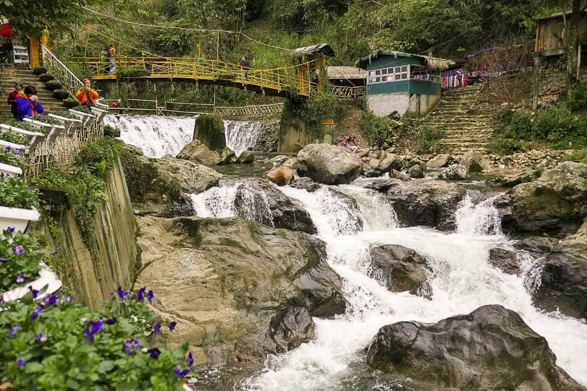 fast water flowing under the bridge at cat cat village sapa itinerary
