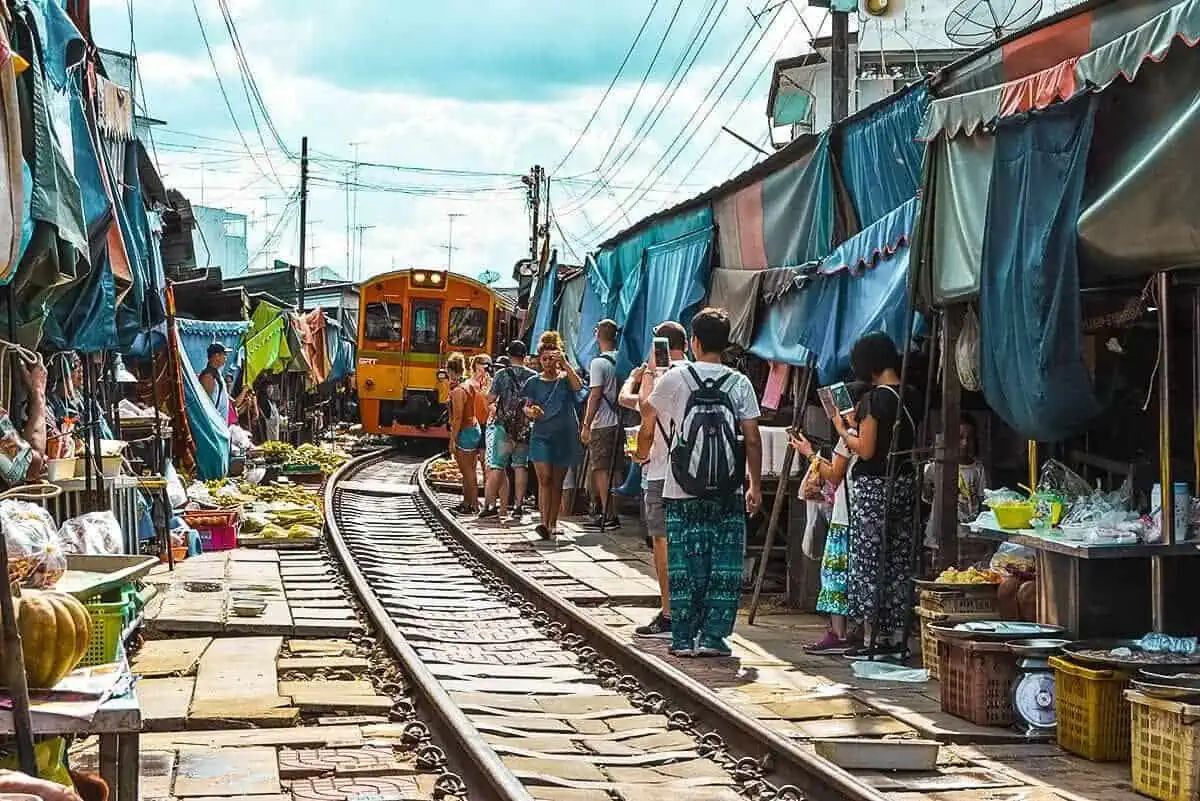 train driving through market on railway tracks bangkok to chiang mai