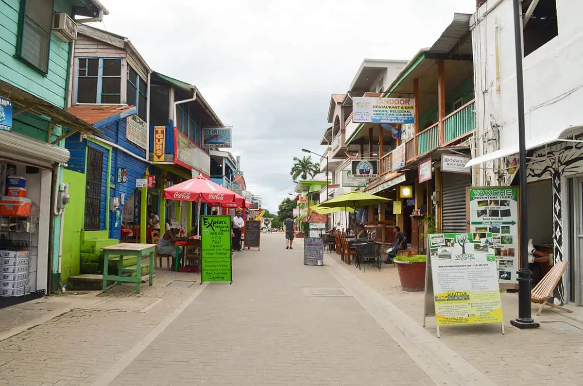 Vibrant pedestrian street in San Ignacio lined with colorful buildings, eclectic shops, and outdoor restaurants