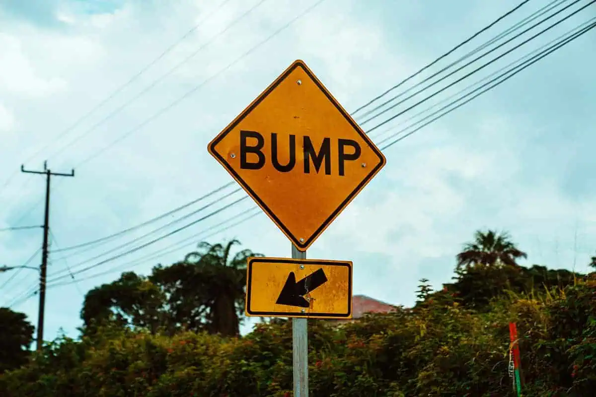 Road safety sign with the word 'BUMP' and an arrow, indicative of the careful driving needed on the journey from Belize airport to San Ignacio.