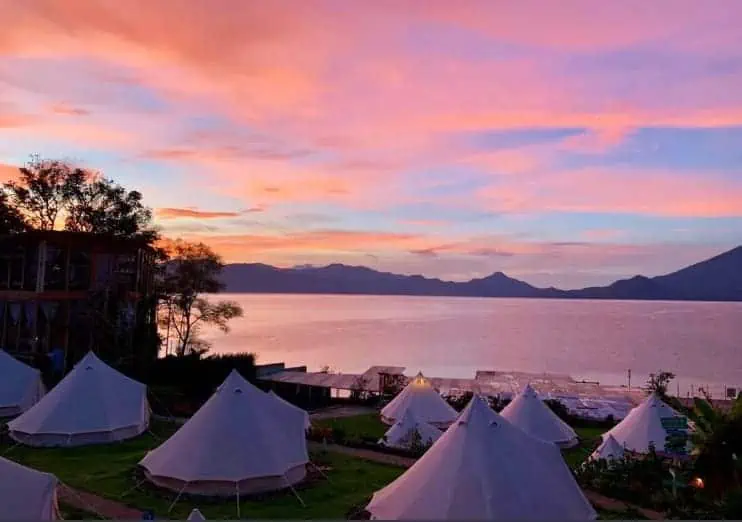 enjoying sunset over the glamping tents which are the shared dorms at free cerveza hostel in lake atitlan