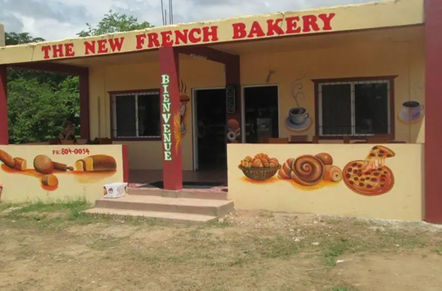 The New French Bakery in San Ignacio, its storefront painted with colorful depictions of baked goods, welcoming visitors to enjoy fresh pastries.