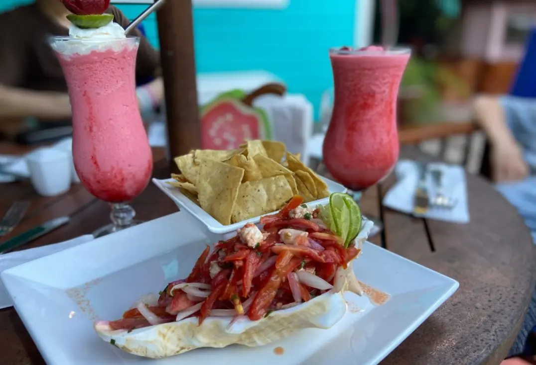 A refreshing pair of strawberry daiquiris accompany a plate of ceviche and tortilla chips, a popular choice at one of the best restaurants in san ignacio