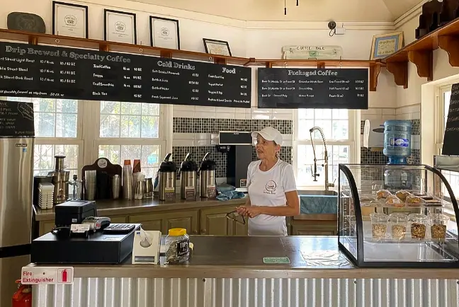 Best Restaurants In San Pedro Belize For Breakfast, Lunch & Dinner 7 Inside the Belize Coffee Company, a friendly barista stands ready behind the counter, showcasing the casual charm of local San Pedro Belize coffee shops, perfect for a morning pick-me-up.