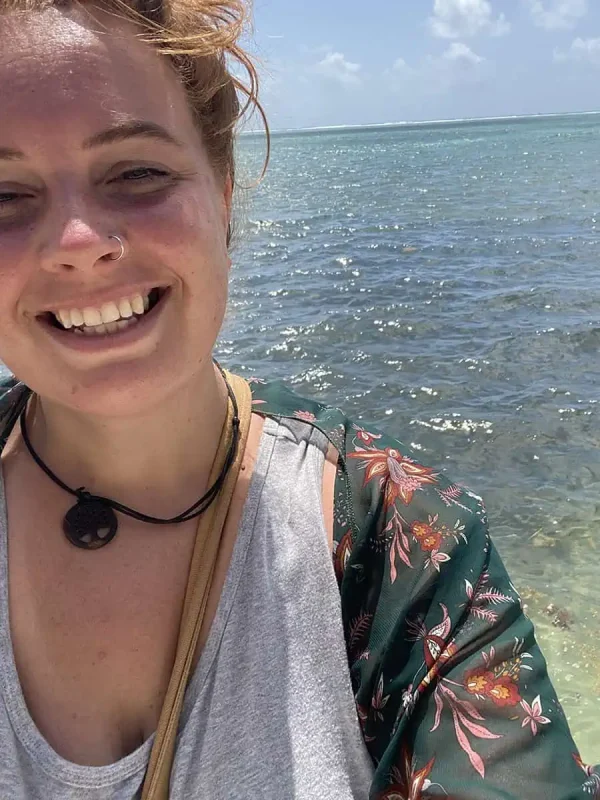 tasha amy smiling on the shores of Ambergris Caye, capturing the personal joy of a relaxing vacation on the island.