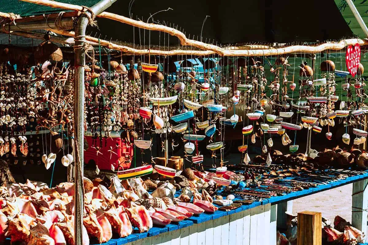 An array of colorful, handmade souvenirs and shells on display at a local market in Ambergris Caye, a perfect place to shop and embrace the local artisan culture.