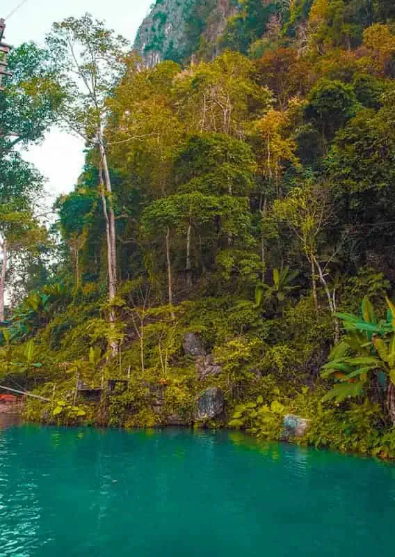 looking across the blue lagoon vang vieng over to the lush jungle