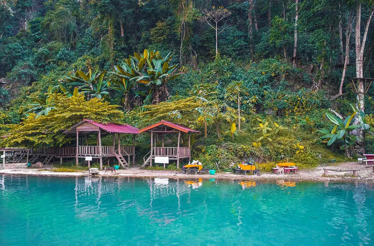 shacks and tables set up for a picnic at blue lagoon three in vang vieng