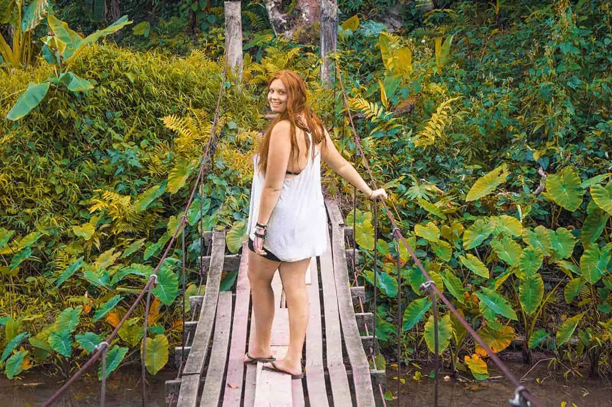 standing on a wooden swing bridge at blue lagoon 3 in vang vieng