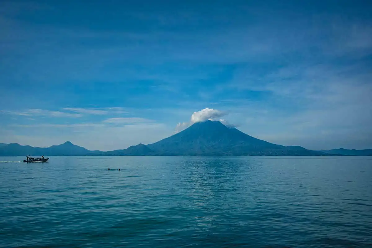 looking over lake aititlan with two people braving the water, and water taxis, in front of santa cruz la laguna
