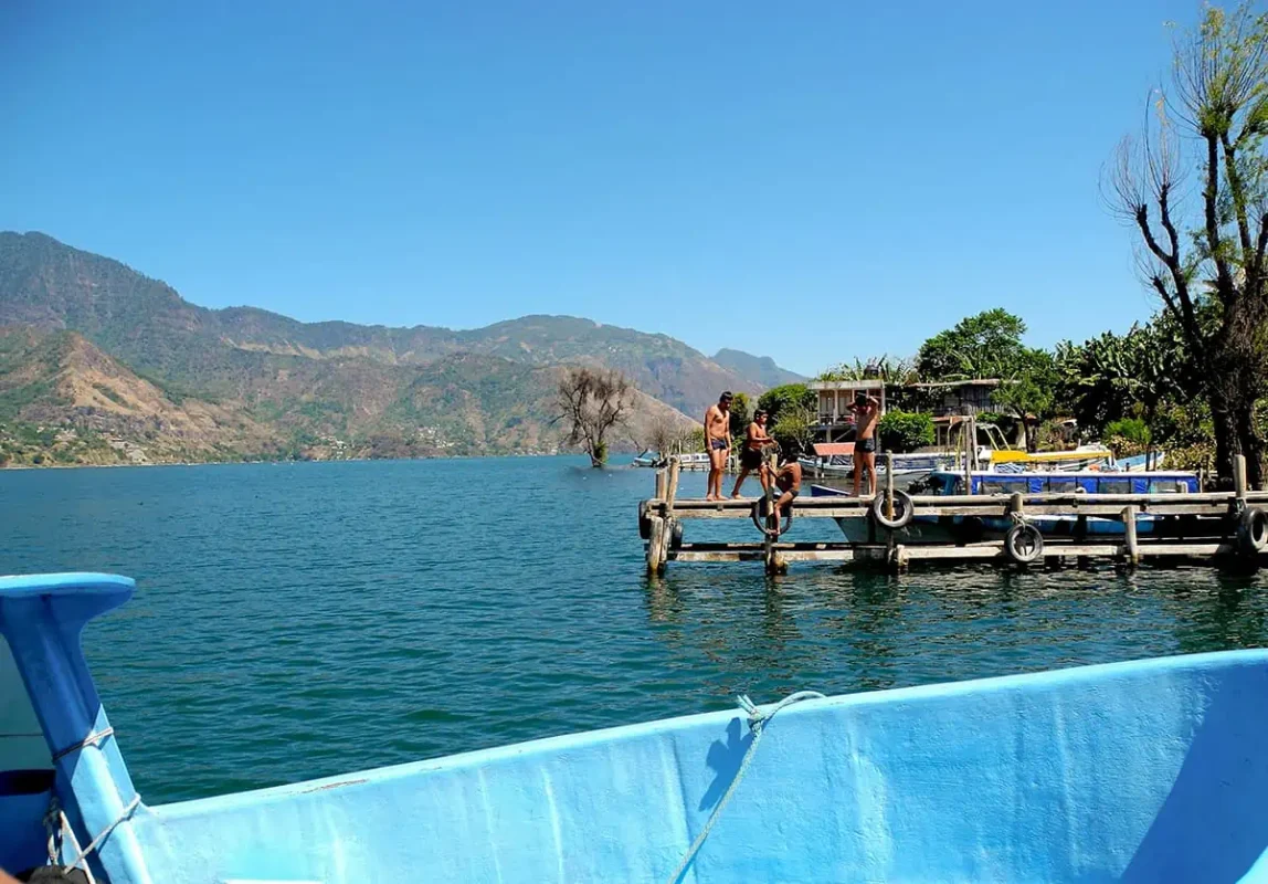 tourists jumping off one of the piers around lake atitlan in the questionable waters