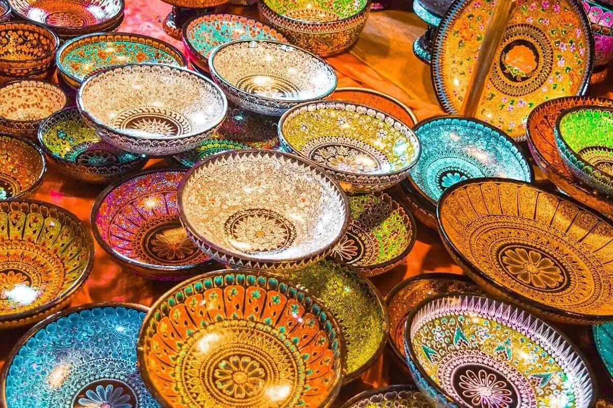 brightly colored decorated bowls with intricate designs on display at the sunday walking street in chiang mai