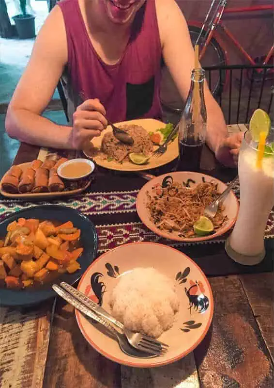 a table of spring rolls, fried rice, pad thai, and sweet and sour tofu, as well as drinks from a restaurant in chiang khong