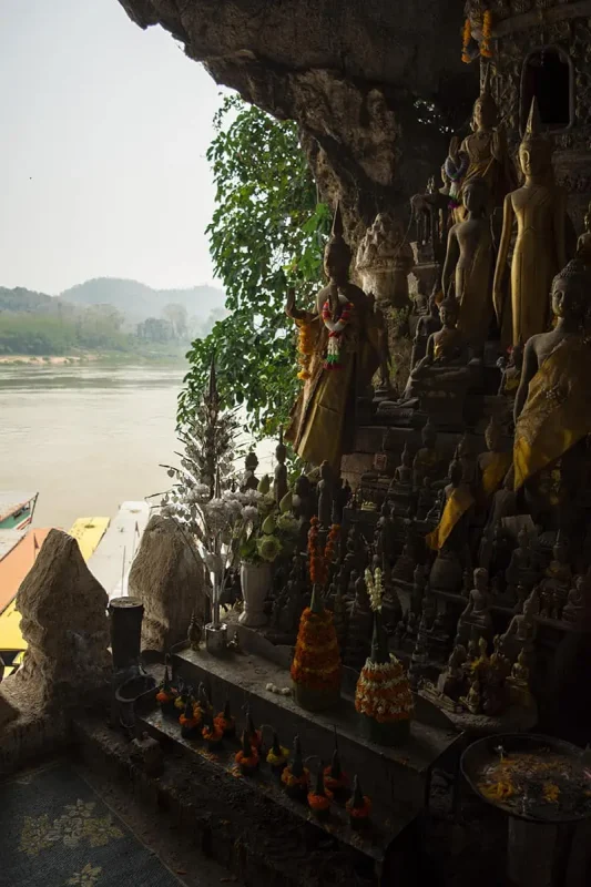 decorative buddhas in pak ou caves looking out to the mekong river