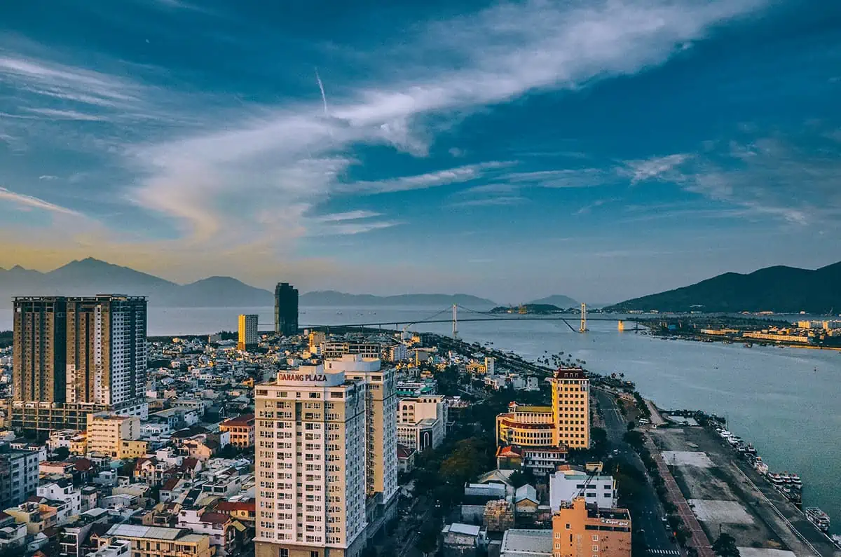 overlooking the city of da nang with large apartment buildings and a bridge over the river and out to sea