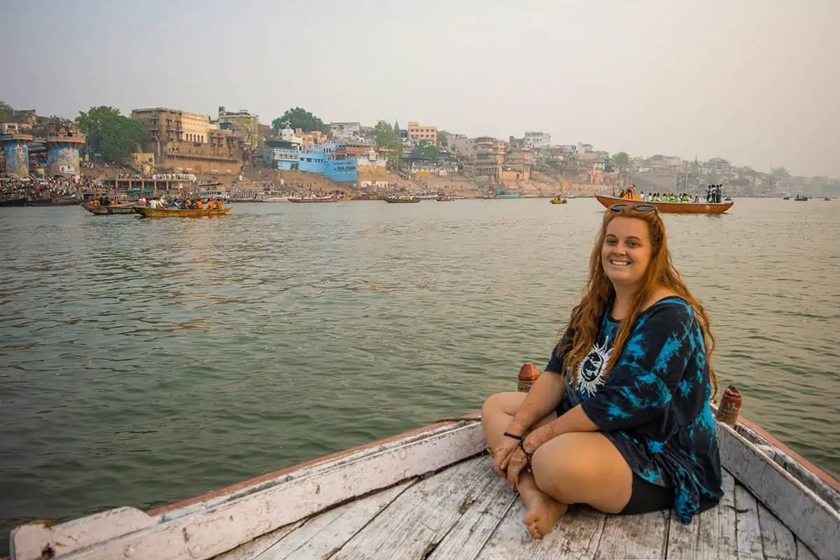 A woman sitting on a boat on the ganges river in varanasi.